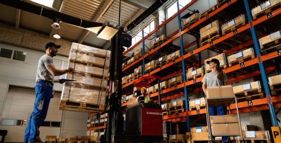 low-angle-view-happy-warehouse-workers-communicating-while-working-with-shipment-industrial-storage-compartment